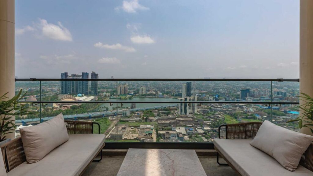View from a spacious balcony of a 4 BHK luxury apartment at PS Aurus Kolkata showcasing the expansive cityscape and green surroundings near EM Bypass Kolkata