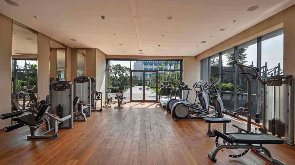 View from a spacious balcony of a 4 BHK luxury apartment at PS Aurus Kolkata showcasing the expansive cityscape and green surroundings near EM Bypass with Indoor Fitness area and Gym