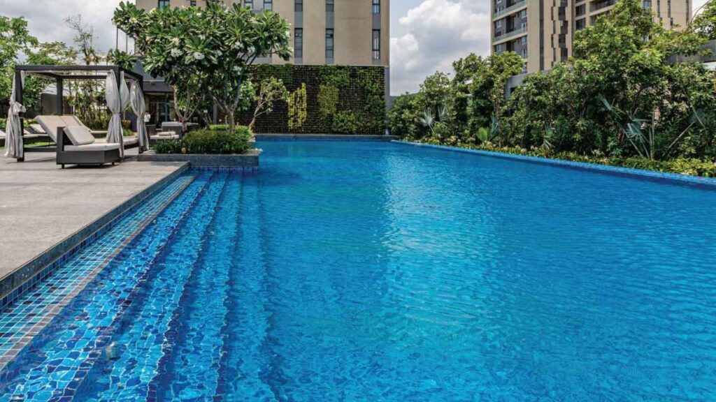 Stunning infinity-edge swimming pool on the podium level of PS Aurus Kolkata, offering a relaxing aquatic retreat for residents of the luxury apartments.